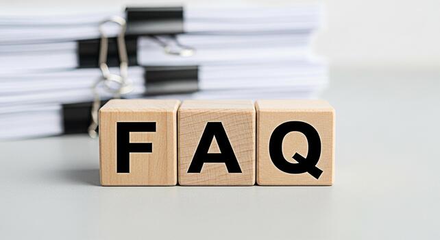 Wooden blocks spelling FAQ on a desk with a stack of documents representing frequently asked questions and information resources in a professional and organized office environment photo