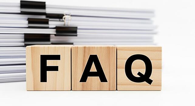 Wooden blocks spelling FAQ in a bright studio setting with a stack of documents representing information access and customer support with a clean minimalist and professional aesthetic photo