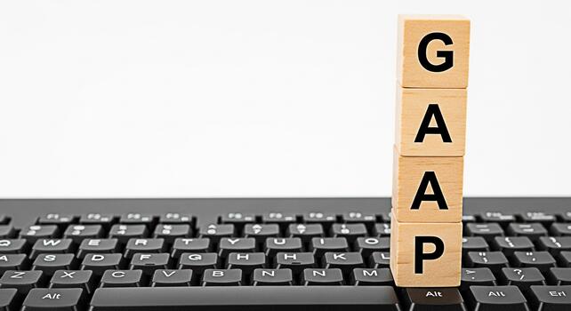 GAAP acronym displayed on wooden blocks sitting on a black computer keyboard representing Generally Accepted Accounting Principles in a modern business environment conveying accuracy and compliance photo