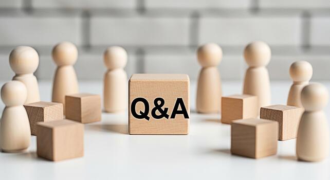 Wooden figures surrounding a QA block on a white table symbolizing a collaborative discussion and knowledge sharing in a bright minimalist setting fostering a sense of community and open communication photo