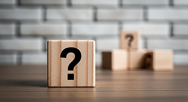 Wooden blocks displaying question marks on a wooden table against a blurred brick wall representing uncertainty and the search for answers in a challenging environment fostering curiosity photo