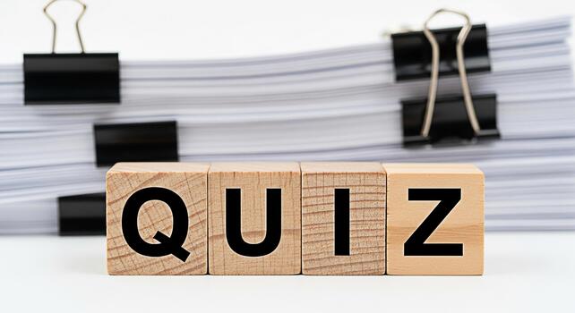 Wooden blocks spelling QUIZ sit in front of a stack of papers with binder clips suggesting a test or assessment in an educational or business setting creating a mood of anticipation and challenge photo