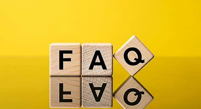 Wooden blocks spelling FAQ on a reflective surface against a bright yellow background representing frequently asked questions and information resources for customer support and online assistance photo