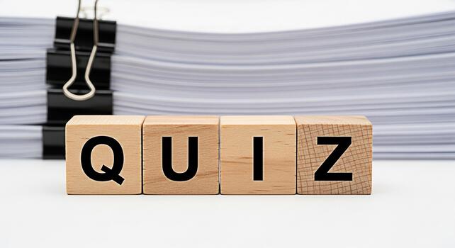 Wooden blocks spelling QUIZ in a bright studio setting representing a test of knowledge and skills with a stack of papers in the background suggesting preparation and assessment photo