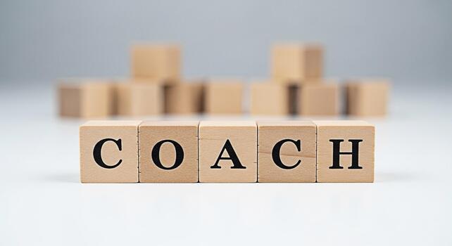 Wooden blocks spelling COACH on a white surface representing guidance and support in a minimalist setting symbolizing mentorship training and personal development for achieving success photo