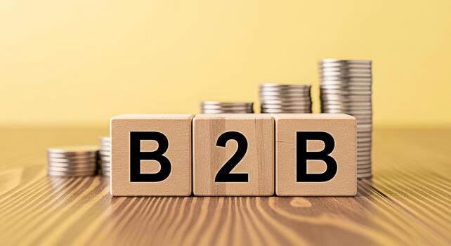 Wooden blocks displaying B2B on a wooden surface with stacks of coins in the background representing business to business transactions and financial growth in a bright and optimistic setting photo