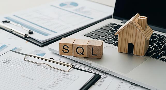 Wooden SQL blocks and a house model resting on a laptop in a bright office symbolizing datadriven real estate investment and the importance of database management for property analysis and decisionmak photo