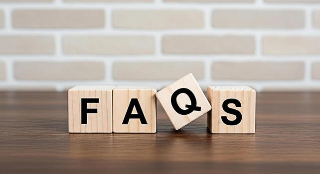 Wooden blocks spelling FAQs on a wooden table against a brick wall representing information and customer support providing answers to common questions and promoting a helpful and informative atmospher photo