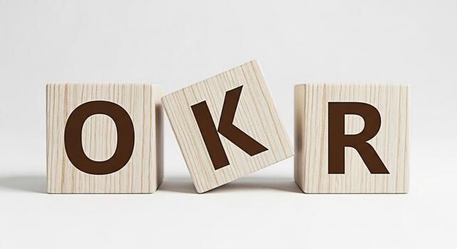 Wooden blocks spelling OKR on a white surface representing Objectives and Key Results a popular goalsetting framework conveying a sense of focus and strategic planning in a minimalist setting photo