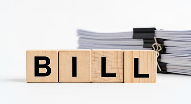 Wooden blocks spelling BILL in a bright studio setting representing financial obligations and the concept of managing expenses and payments with a sense of responsibility and awareness photo