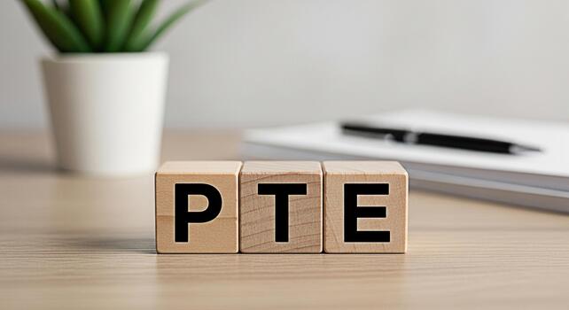 Wooden blocks spelling PTE on a bright desk with a notebook and pen symbolizing preparation for the Pearson Test of English and academic success creating a focused and professional learning environmen photo