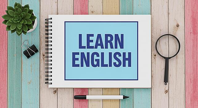 Open notebook displaying Learn English on a colorful wooden desk surrounded by a succulent binder clip pen and magnifying glass creating a bright and inviting educational atmosphere photo