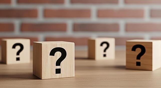 Wooden blocks displaying question marks on a wooden table against a brick wall representing uncertainty inquiry and the search for answers in a challenging and thoughtprovoking environment photo