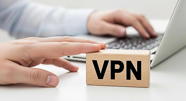 Person typing on a laptop with a wooden block displaying VPN on a white desk symbolizing secure online browsing and data protection for enhanced digital privacy and freedom photo