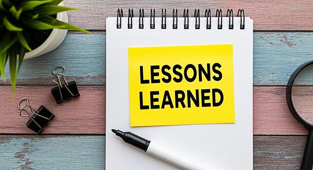 Lessons Learned A bright yellow sticky note with the words Lessons Learned on a notepad placed on a rustic wooden desk with office supplies symbolizing reflection and continuous improvement photo