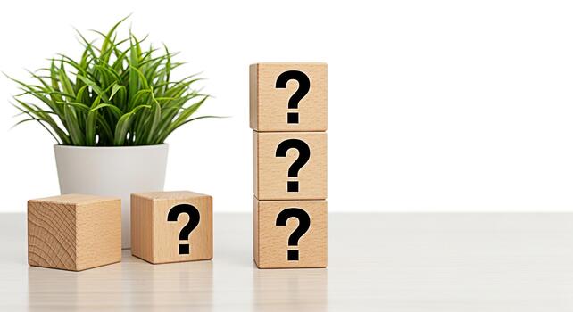 Wooden blocks displaying question marks next to a potted plant on a bright white table creating a sense of uncertainty and curiosity in a clean minimalist setting ideal for educational or problemsolvi photo