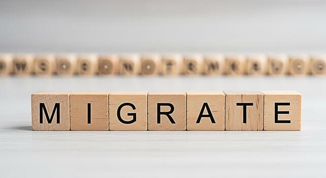 Wooden blocks spelling MIGRATE on a white surface conveying the concept of relocation immigration or moving to a new place symbolizing change and new beginnings in a clean and minimalist setting photo