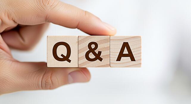 Hand holding wooden blocks with the letters QA in a bright studio setting representing questions and answers knowledge sharing and interactive communication for business and education photo