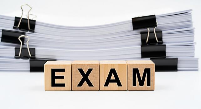 Wooden blocks spelling EXAM in front of a stack of papers symbolizing academic pressure and the importance of preparation in a bright clean environment conveying a sense of seriousness and focus photo