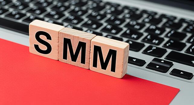 Wooden blocks spelling SMM resting on a laptop keyboard and a red surface representing social media marketing strategies in a digital environment conveying a modern and technological concept photo
