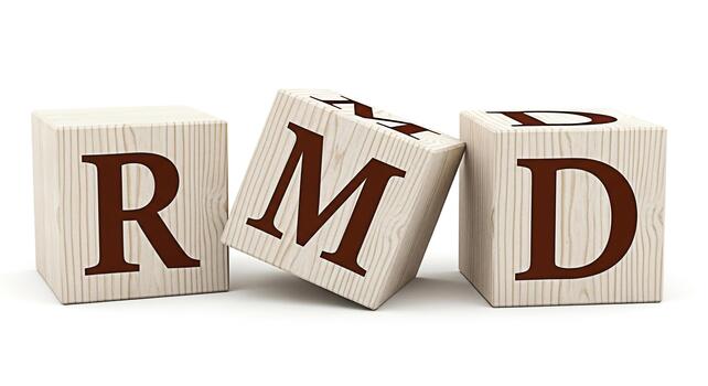 Wooden blocks spelling RMD on a white surface with the middle block tilted creating a playful and educational atmosphere ideal for learning and development concepts in a bright studio setting photo