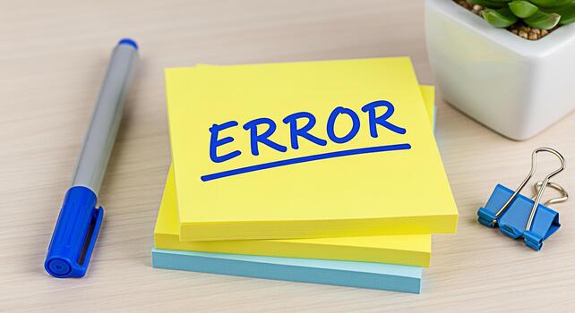 Yellow sticky note displaying the word ERROR in blue ink on a wooden desk symbolizing a problem mistake or warning in a workplace or educational setting creating a sense of urgency and attention photo