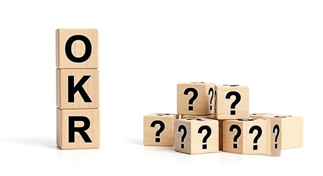 Wooden blocks displaying OKR and question marks on a white background representing goal setting and uncertainty in business strategy and objectives key results creating a sense of challenge and opport photo