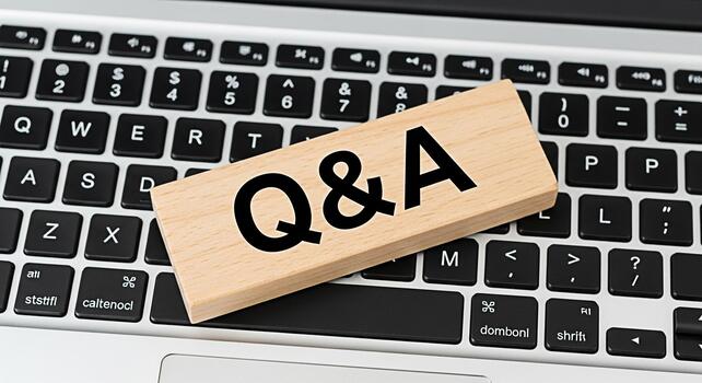 Wooden block displaying QA resting on a modern laptop keyboard symbolizing information access and problemsolving in a digital environment fostering a sense of clarity and understanding photo