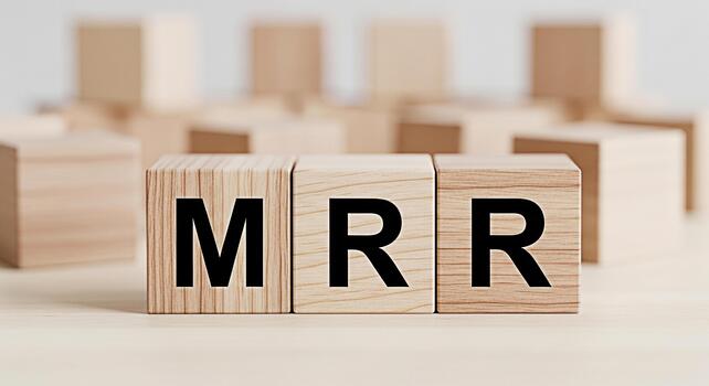 Wooden blocks displaying MRR on a bright surface representing Monthly Recurring Revenue in a clean minimalist setting symbolizing financial stability and predictable income for business growth photo