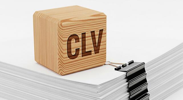 Wooden block displaying CLV on a stack of white paper representing Customer Lifetime Value in a bright minimalist office setting symbolizing business strategy and financial planning for longterm succe photo
