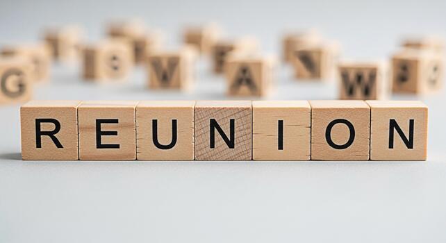 Wooden blocks spelling REUNION on a gray surface suggesting a gathering or meeting in a simple clean setting evoking feelings of nostalgia connection and the importance of relationships and community photo