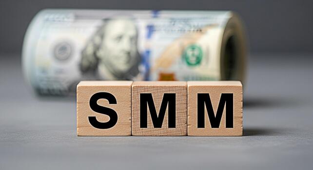 Wooden blocks displaying SMM in a studio setting symbolizing social media marketing strategies for financial growth and business success with a roll of US dollar bills in the background photo
