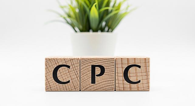 Wooden blocks displaying the letters CPC representing Cost Per Click sitting on a white surface with a small green plant in the background symbolizing growth and investment in online advertising strat photo