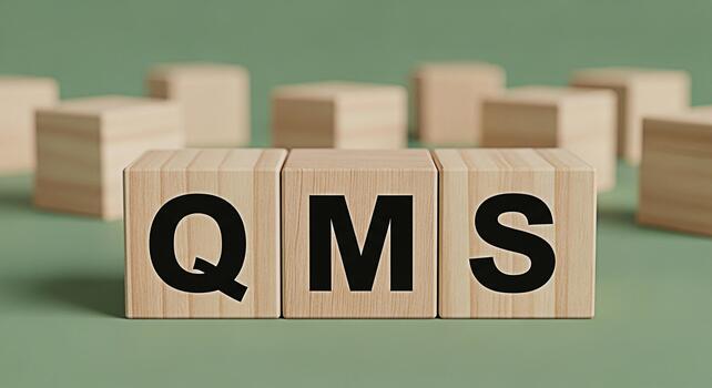 Wooden blocks displaying QMS on a green surface representing Quality Management System in a business setting conveying precision and structured organization photo