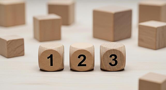 Wooden blocks displaying numbers 1 2 and 3 on a light wooden surface representing sequential steps and a simple minimalist approach to learning and development photo