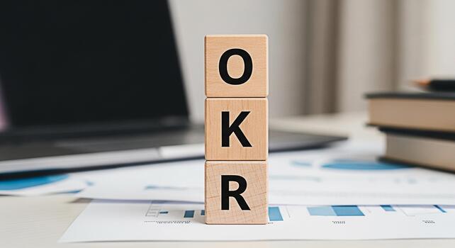 Wooden blocks displaying OKR acronym on a modern office desk symbolizing Objectives and Key Results a strategic framework for goal setting and performance tracking in a business environment photo