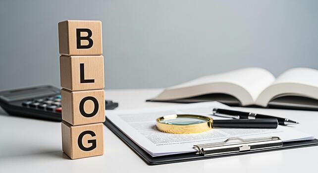 Wooden blocks spelling BLOG on a white desk with an open book and calculator symbolizing online content creation and financial analysis in a professional setting promoting a concept of knowledge and g photo