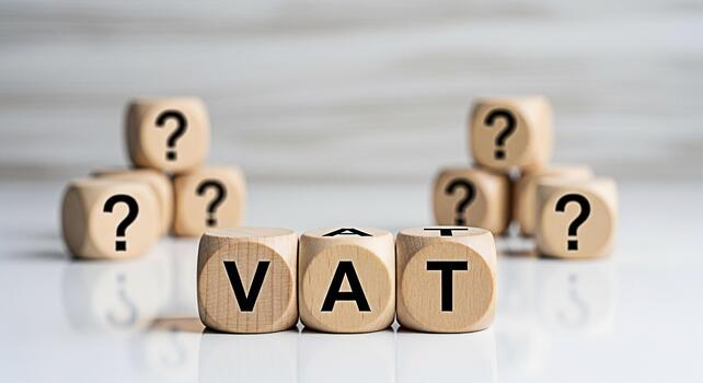 de madera bloques ortografía fuera IVA en un reflexivo superficie rodeado por pregunta marca bloques posando preguntas acerca de valor adicional impuesto y financiero incertidumbre en un moderno negocio ambiente foto