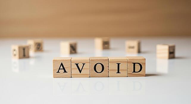 Wooden blocks spelling AVOID on a white surface suggesting prevention and caution in a clean minimalist setting emphasizing the importance of foresight and strategic decisionmaking to mitigate risks a photo
