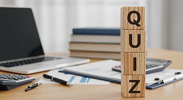 Wooden blocks spelling QUIZ stand prominently on a desk in a bright office surrounded by a laptop calculator and documents creating an atmosphere of learning and assessment photo