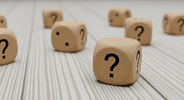 Wooden dice displaying question marks scattered on a bright wooden surface representing uncertainty challenges and the need for problemsolving in a business or personal context photo