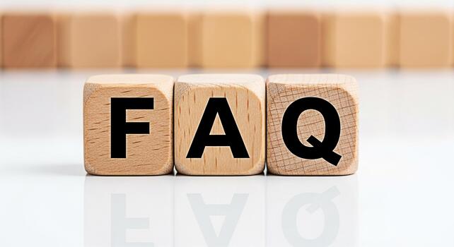 Wooden blocks spelling FAQ on a reflective white surface presenting a clear and concise message about frequently asked questions ideal for online help centers and customer support resources photo