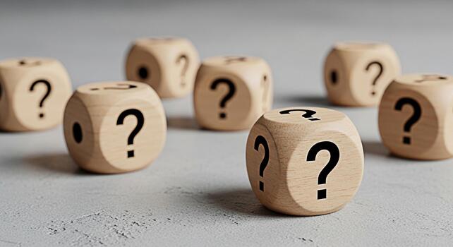 Wooden dice displaying question marks on a textured gray surface representing uncertainty and the search for answers in a conceptual and thoughtprovoking composition ideal for problemsolving and decis photo