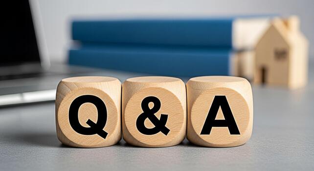 Wooden blocks displaying QA on a desk with a laptop and books representing information and knowledge encouraging questions and answers in a learning or business environment fostering curiosity photo
