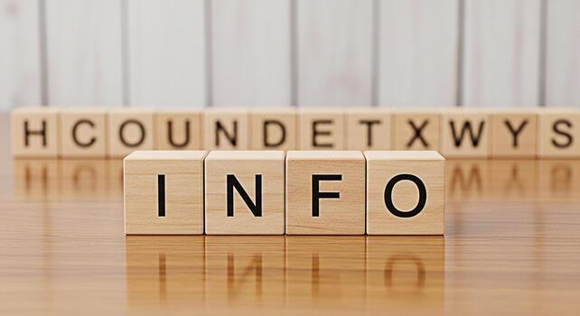 Wooden blocks spelling INFO on a reflective wooden surface representing information and knowledge with blurred letters in the background creating a sense of focus and clarity photo