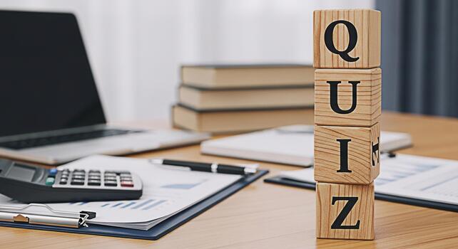 Wooden blocks spelling QUIZ stand prominently on a desk amidst financial reports a calculator and a laptop creating a learning and assessment environment for business and educational concepts photo