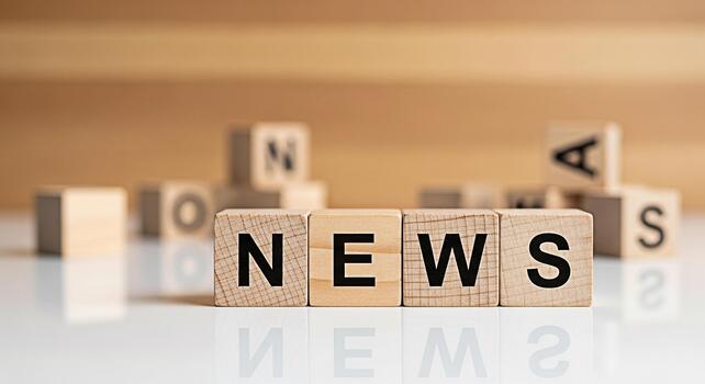 Wooden blocks spelling NEWS on a reflective surface in a studio setting conveying a message of information current events and media awareness in a simple and clean composition photo
