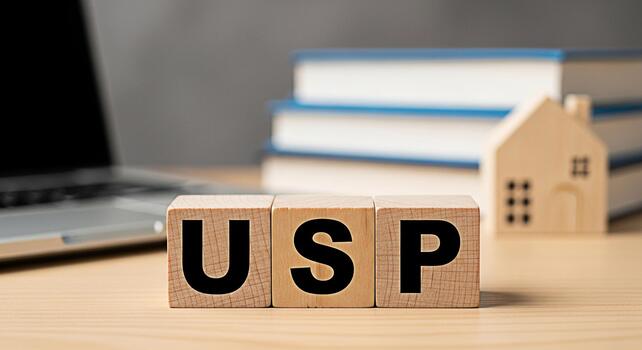 Wooden blocks displaying USP on a desk with laptop books and a house model representing unique selling proposition in a business environment conveying a sense of strategy and differentiation photo