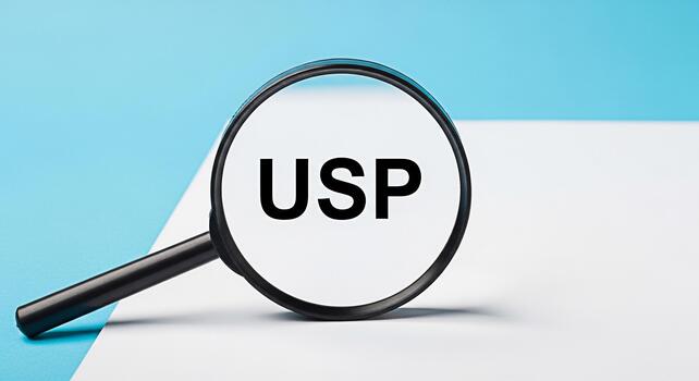 Magnifying glass focusing on USP text on a white surface against a blue background representing unique selling proposition business strategy and competitive advantage in a clear and concise manner photo