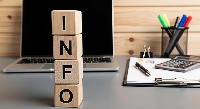 Wooden blocks spelling INFO on a desk with a laptop calculator and stationery conveying knowledge and data in a modern office environment emphasizing business intelligence and information management photo